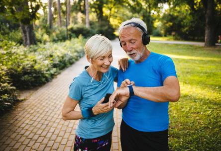 Couple looking at their activity trackers and smartphone health apps