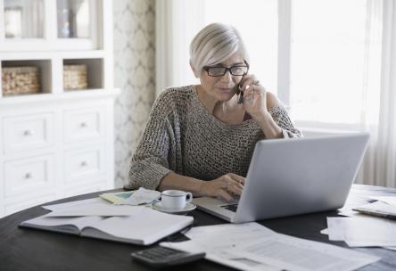 Woman sitting at computer talking to insurance customer service