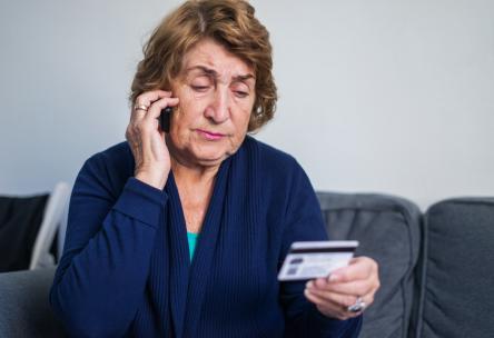 older woman looking at credit card