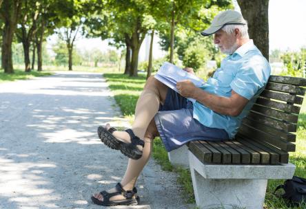 older man sitting down and reading the newspaper