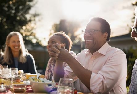 Photo: Man laughing at group outdoor dinner