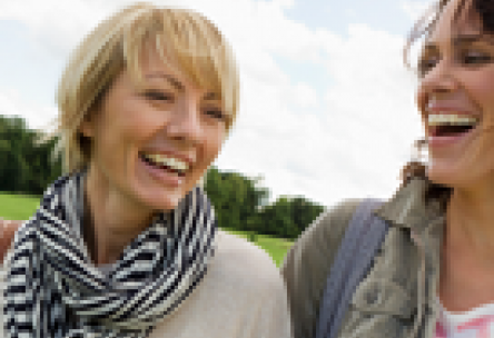 two women laughing outdoors