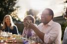 Photo: Man laughing at group outdoor dinner